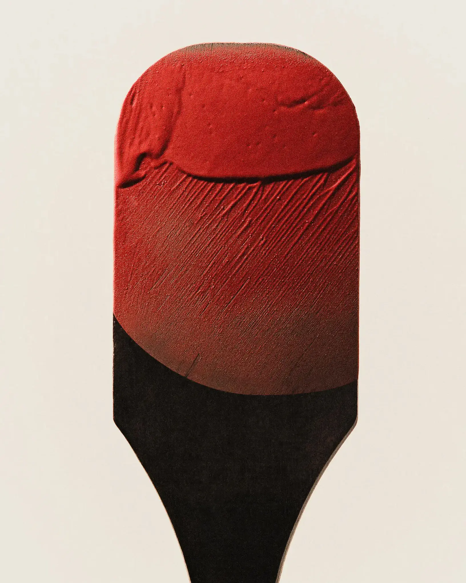 A red and black lipstick bullet, close up
